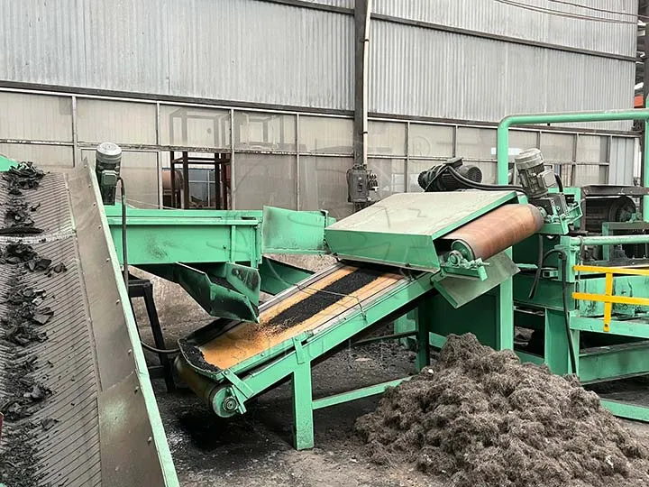 Mchakato wa usafi wa poda ya mpira, unaonyesha nyenzo za gari zilizogawanyika kwenye conveyor inayokaribia separator ya sumaku, na waya wa chuma uliotenganishwa upande wa pembeni.