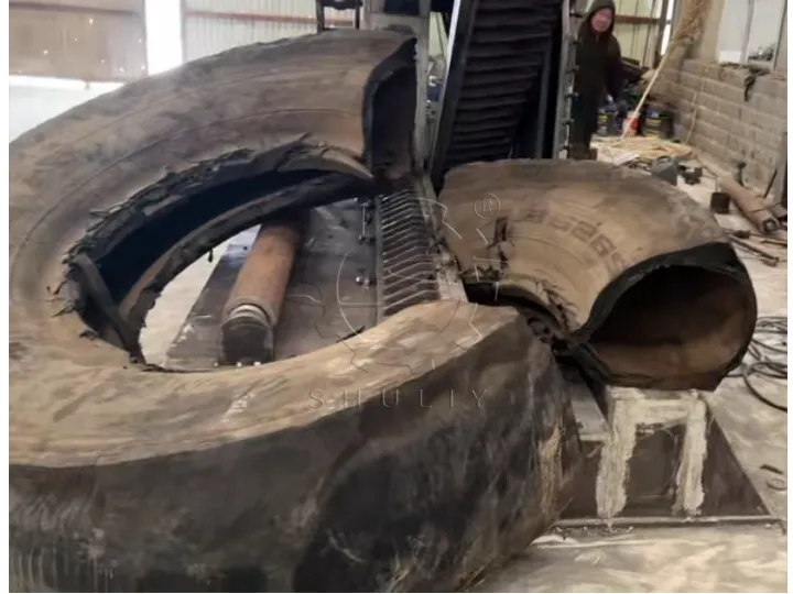 Powerful hydraulic shear biting through the thick rubber of a giant OTR tire